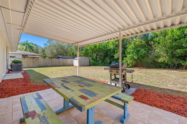 view of patio with area for grilling, a storage shed, and central AC