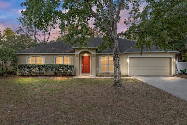 20390 SW 57th St, Dunnellon, FL 34431 - ranch-style home featuring stucco siding, concrete driveway, a garage, a shingled roof, and a front lawn
