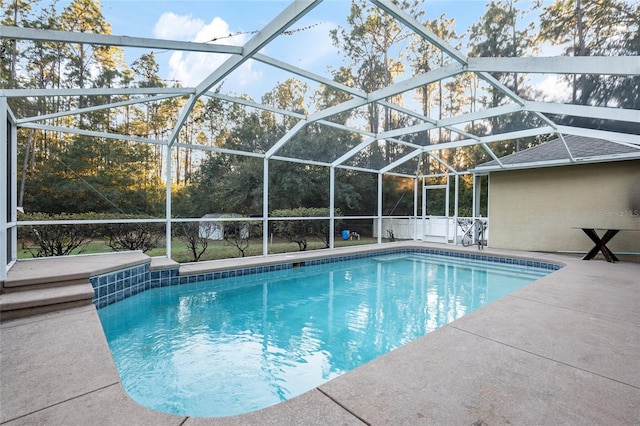 view of pool featuring glass enclosure and a patio area