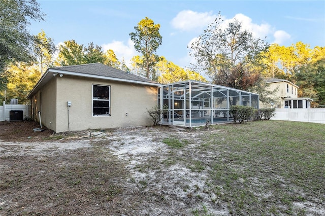 back of property featuring a swimming pool, a lanai, a yard, and central AC