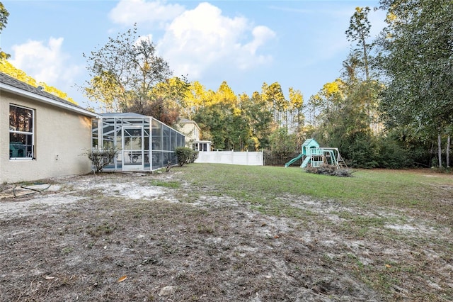20390 SW 57th St, Dunnellon, FL 34431 - view of yard with a playground, glass enclosure, and view of wooded area