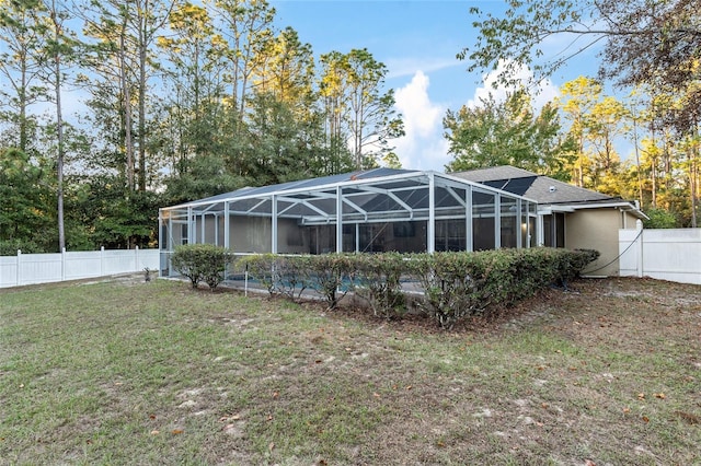 back of house with a lanai and a yard