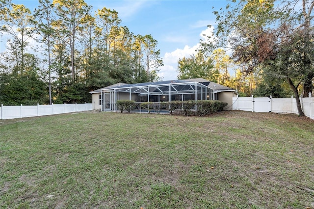 20390 SW 57th St, Dunnellon, FL 34431 - rear view of property with glass enclosure, a gate, and view of scattered trees