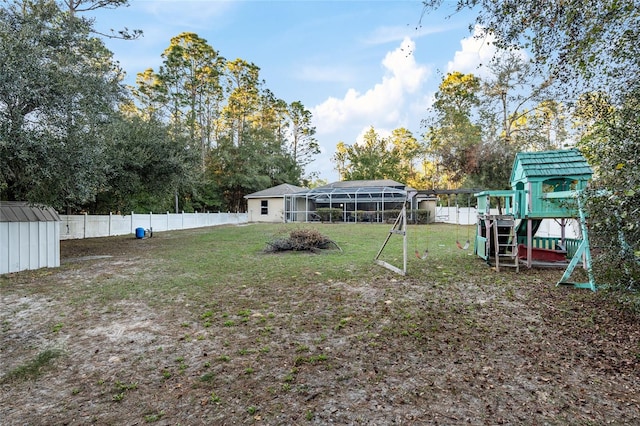 view of yard featuring a playground and glass enclosure