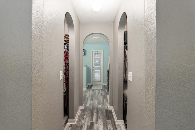 20390 SW 57th St, Dunnellon, FL 34431 - hall with wood finished floors, a textured wall, arched walkways, and baseboards