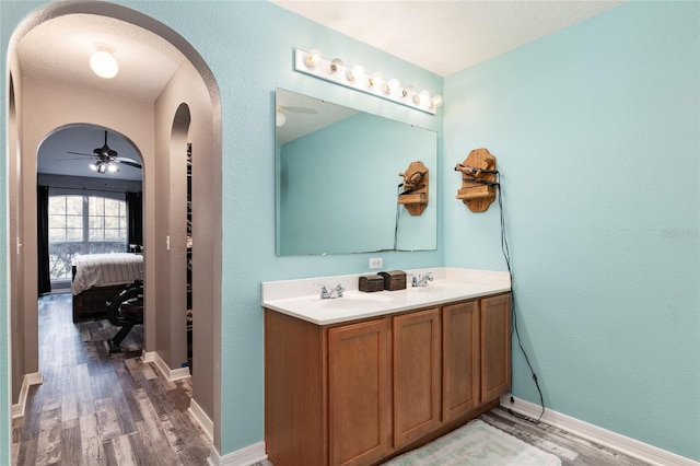 bathroom with hardwood / wood-style floors, ceiling fan, and vanity