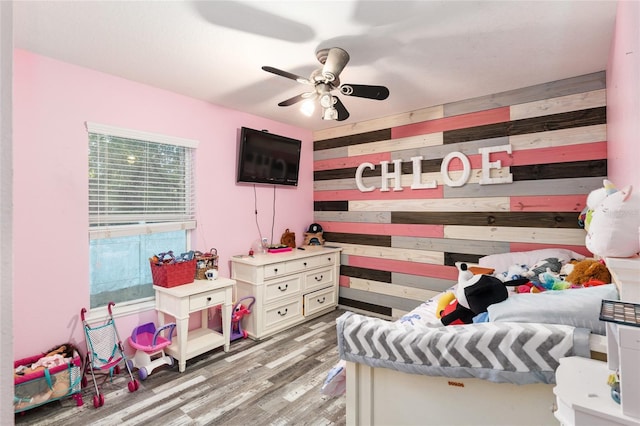 20390 SW 57th St, Dunnellon, FL 34431 - bedroom with wood walls, light wood-type flooring, and a ceiling fan