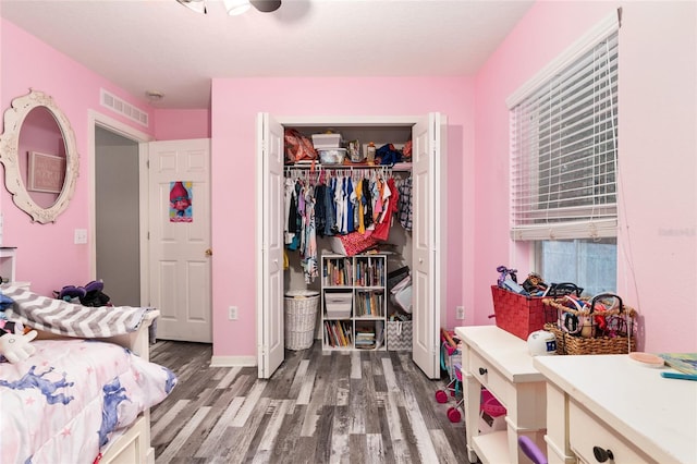 bedroom featuring hardwood / wood-style flooring, ceiling fan, and a closet