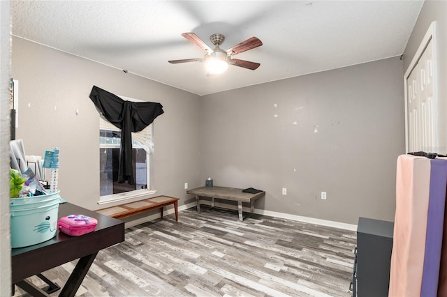 interior space featuring hardwood / wood-style floors, ceiling fan, and a textured ceiling