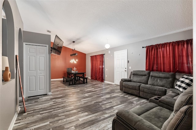 living room featuring a textured ceiling, dark hardwood / wood-style floors, and lofted ceiling