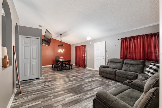 20390 SW 57th St, Dunnellon, FL 34431 - living area featuring wood finished floors, baseboards, vaulted ceiling, arched walkways, and a textured ceiling