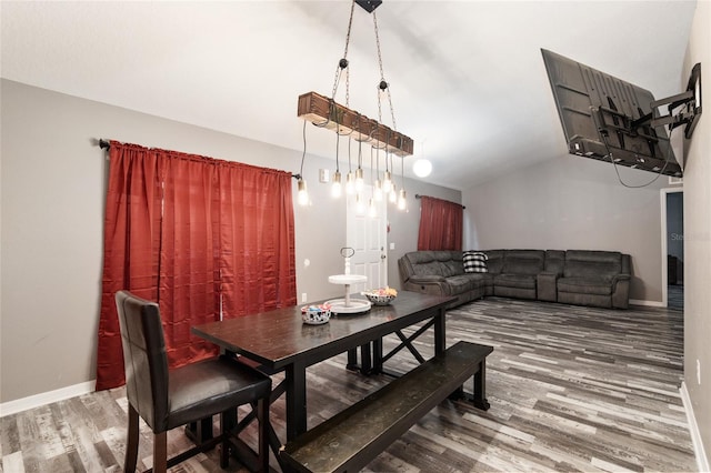 dining area featuring wood-type flooring and lofted ceiling