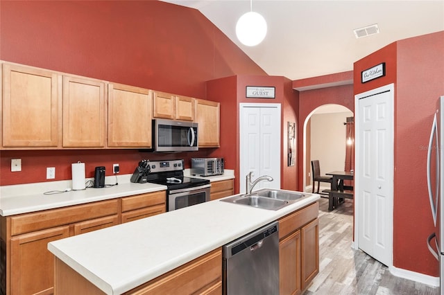 20390 SW 57th St, Dunnellon, FL 34431 - kitchen with appliances with stainless steel finishes, a sink, arched walkways, light wood-style flooring, and light countertops