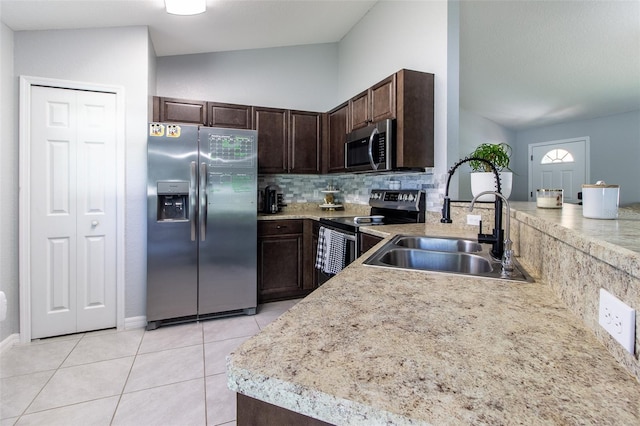 17023 SW 41st Avenue Rd, Ocala, FL 34473 - kitchen with lofted ceiling, sink, light tile patterned floors, appliances with stainless steel finishes, and dark brown cabinetry