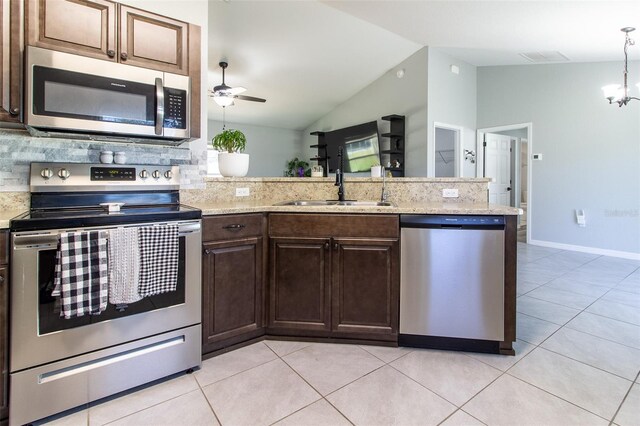 17023 SW 41st Avenue Rd, Ocala, FL 34473 - kitchen with lofted ceiling, backsplash, light tile patterned floors, appliances with stainless steel finishes, and kitchen peninsula