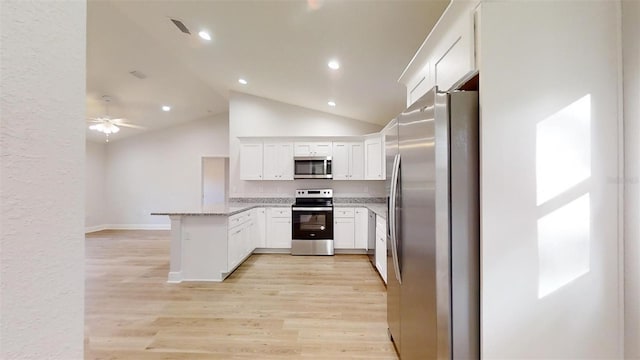 kitchen featuring kitchen peninsula, stainless steel appliances, vaulted ceiling, light hardwood / wood-style flooring, and white cabinets