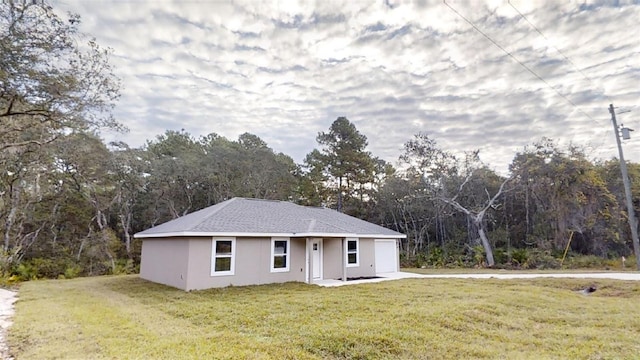 single story home with a front yard and a garage