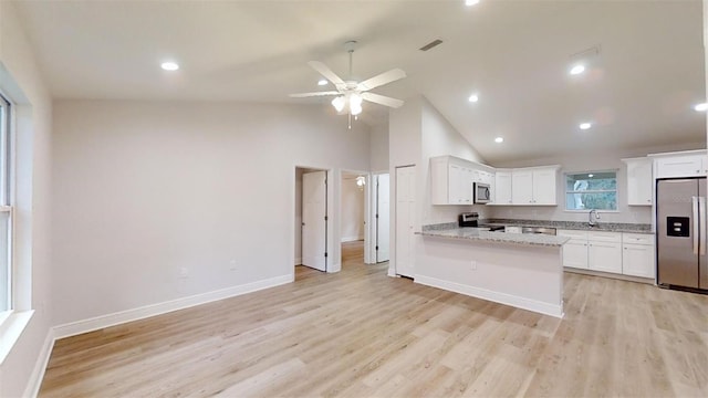 kitchen with ceiling fan, light stone countertops, light hardwood / wood-style flooring, white cabinets, and appliances with stainless steel finishes