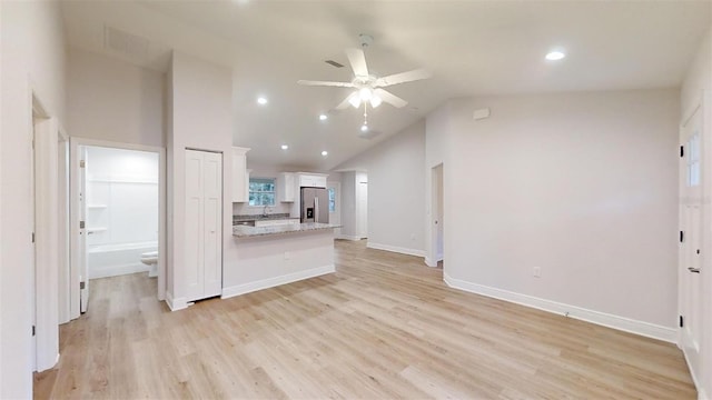 kitchen featuring stainless steel fridge, light wood-type flooring, white cabinetry, and ceiling fan