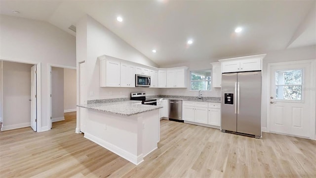 kitchen featuring light stone counters, kitchen peninsula, light hardwood / wood-style floors, white cabinets, and appliances with stainless steel finishes