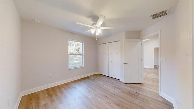 unfurnished bedroom featuring ceiling fan, light hardwood / wood-style floors, and a closet