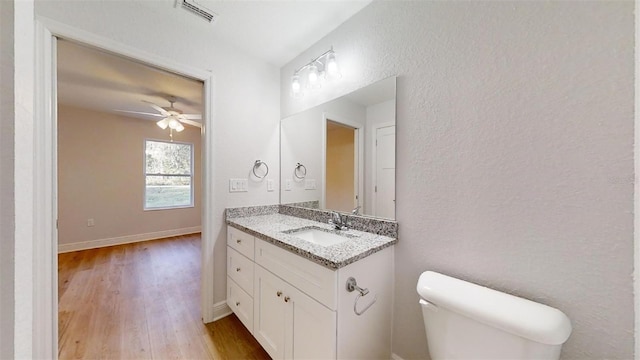 bathroom featuring ceiling fan, hardwood / wood-style floors, vanity, and toilet