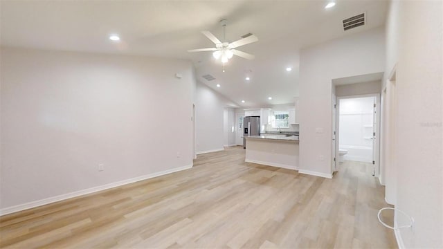 unfurnished living room with ceiling fan, high vaulted ceiling, and light hardwood / wood-style flooring