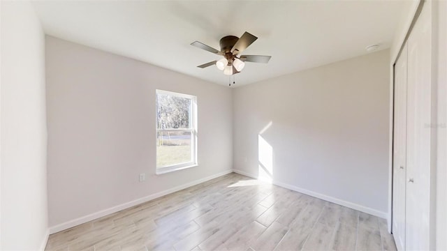 spare room featuring light hardwood / wood-style floors and ceiling fan