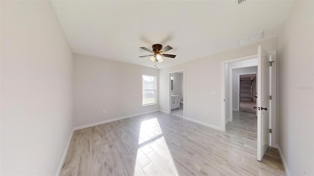 unfurnished bedroom featuring light wood-type flooring, connected bathroom, and ceiling fan