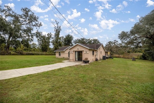 view of front of property featuring a front yard and central AC