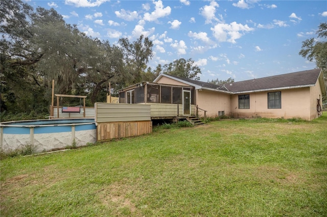 rear view of house featuring a yard and a sunroom