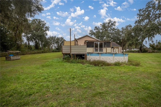 rear view of house featuring a yard and a deck