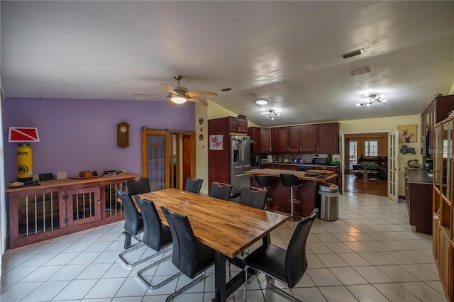 dining room with ceiling fan, lofted ceiling, light tile patterned floors, and french doors