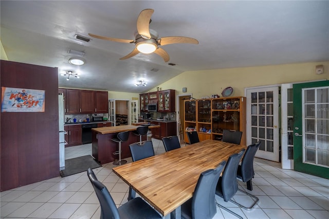 tiled dining space with vaulted ceiling and ceiling fan