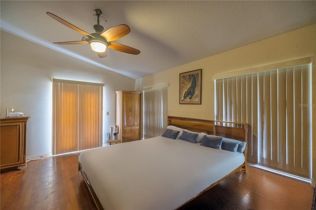 bedroom featuring a textured ceiling, ceiling fan, dark hardwood / wood-style floors, and vaulted ceiling