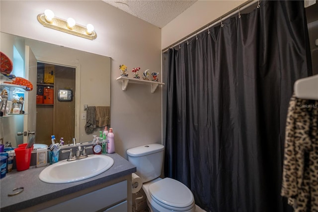 bathroom with vanity, toilet, and a textured ceiling