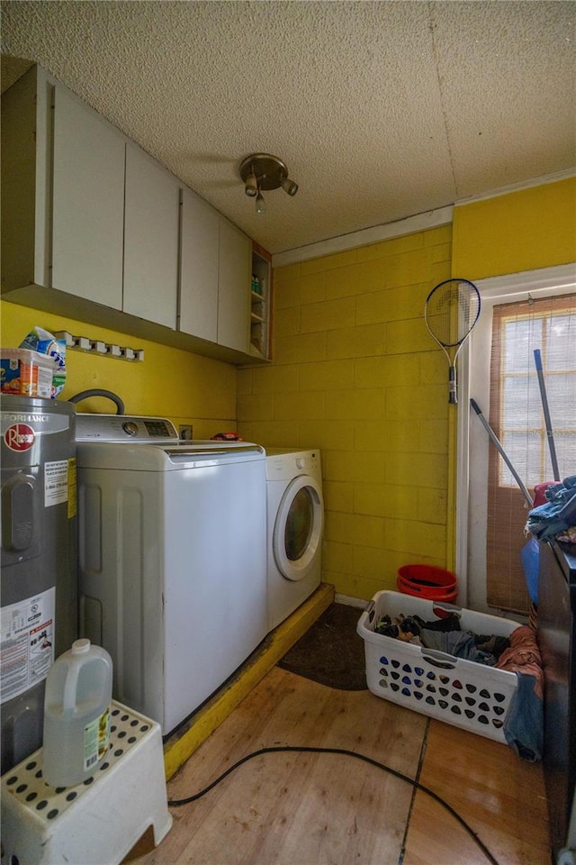 washroom with cabinets, independent washer and dryer, electric water heater, and a textured ceiling