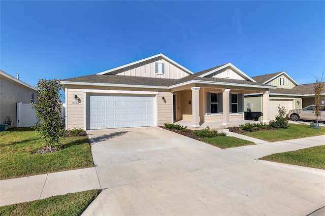 view of front facade featuring a garage, a front yard, and covered porch