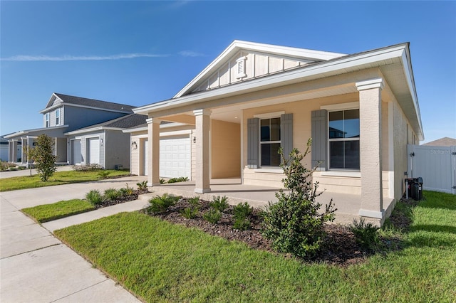 view of front of property with a garage, a front yard, and a porch