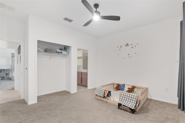 carpeted bedroom featuring ceiling fan and a closet