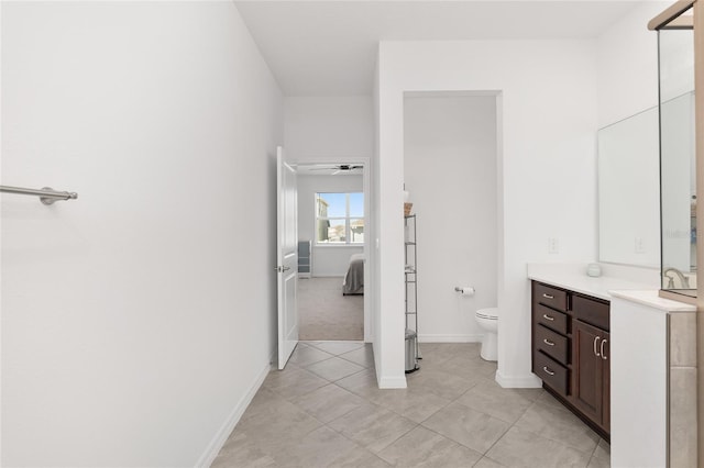 bathroom with tile patterned flooring, vanity, toilet, and ceiling fan