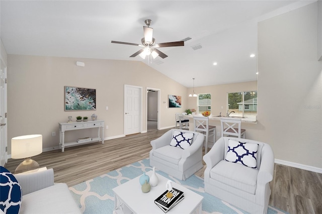 living room with vaulted ceiling, light wood-style flooring, visible vents, and baseboards