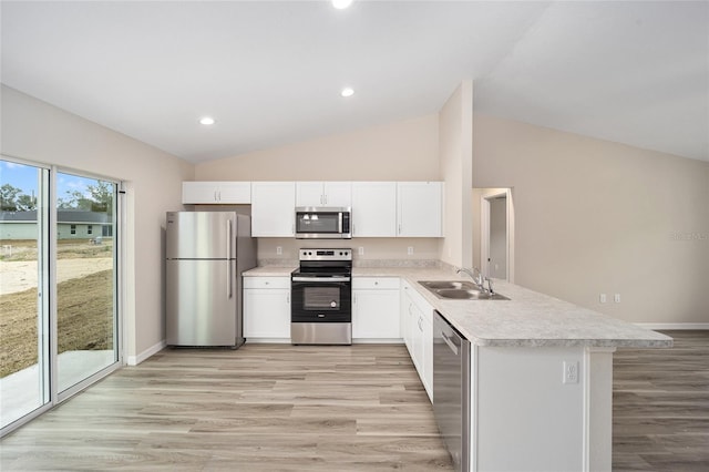 kitchen featuring a peninsula, stainless steel appliances, light countertops, white cabinetry, and a sink