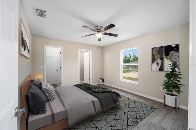 carpeted bedroom with a ceiling fan, visible vents, and baseboards