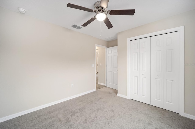 unfurnished bedroom with baseboards, visible vents, a closet, and light colored carpet