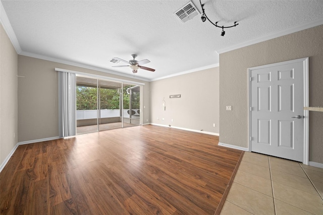 empty room with wood-type flooring, a textured ceiling, ceiling fan, and crown molding