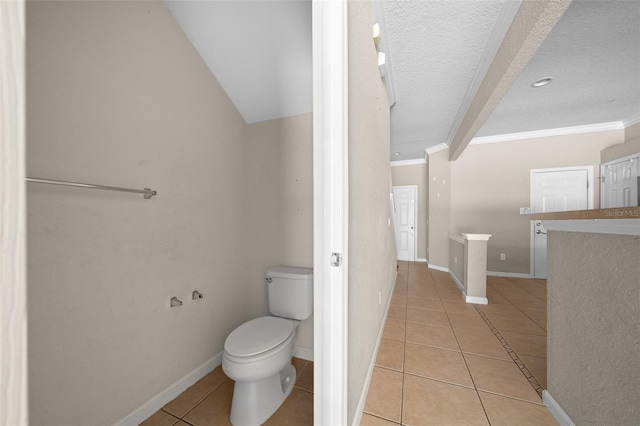 bathroom with tile patterned flooring, a textured ceiling, toilet, and ornamental molding