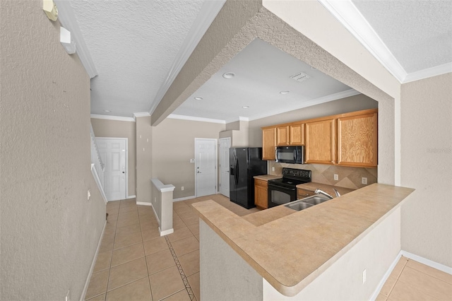 kitchen with kitchen peninsula, decorative backsplash, ornamental molding, sink, and black appliances