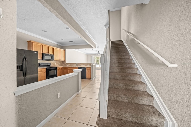 kitchen with kitchen peninsula, crown molding, a textured ceiling, light tile patterned floors, and black appliances