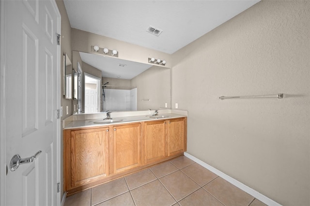 bathroom featuring tile patterned flooring, vanity, and walk in shower